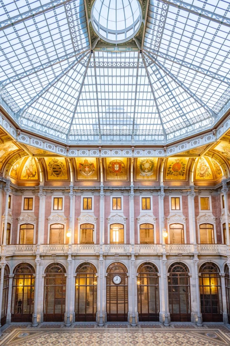 The Pátio das Nações at Palácio da Bolsa set for a seated wedding dinner beneath the octagonal glass dome.